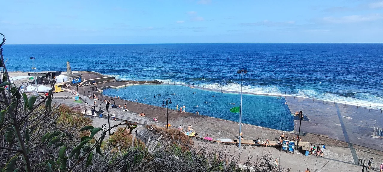 Piscinas de agua azul y faro en la costa de Bajamar