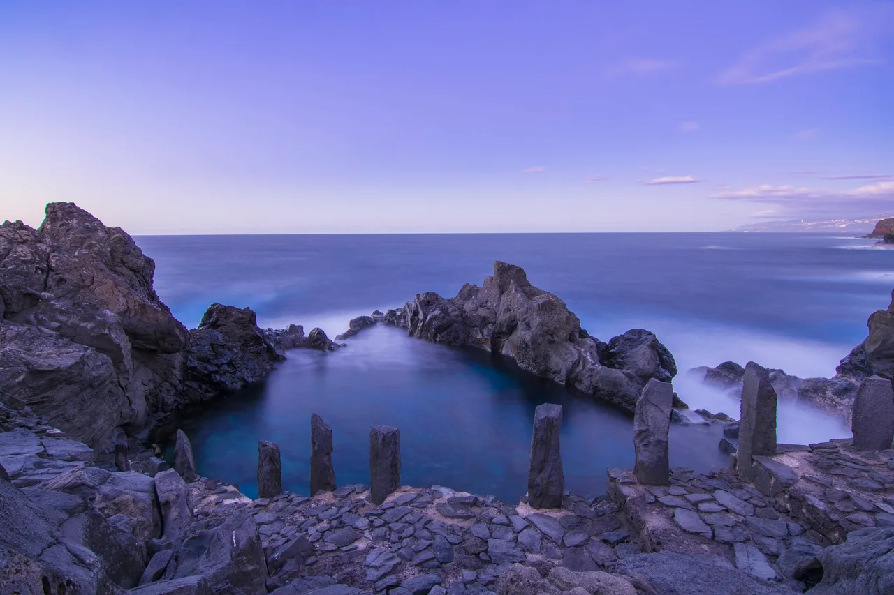 Agua azul del Charco de La Laja entre oscuras rocas volcánicas